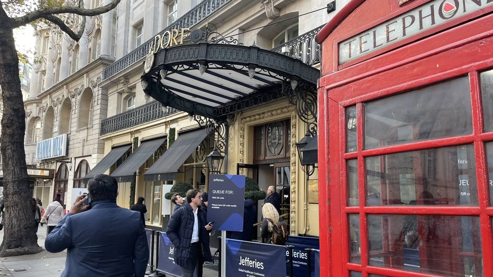 A London street with a red phone box outside a conference venue